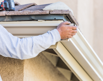 A professional technician replacing gutters on a charming residential home in Cotati, CA.