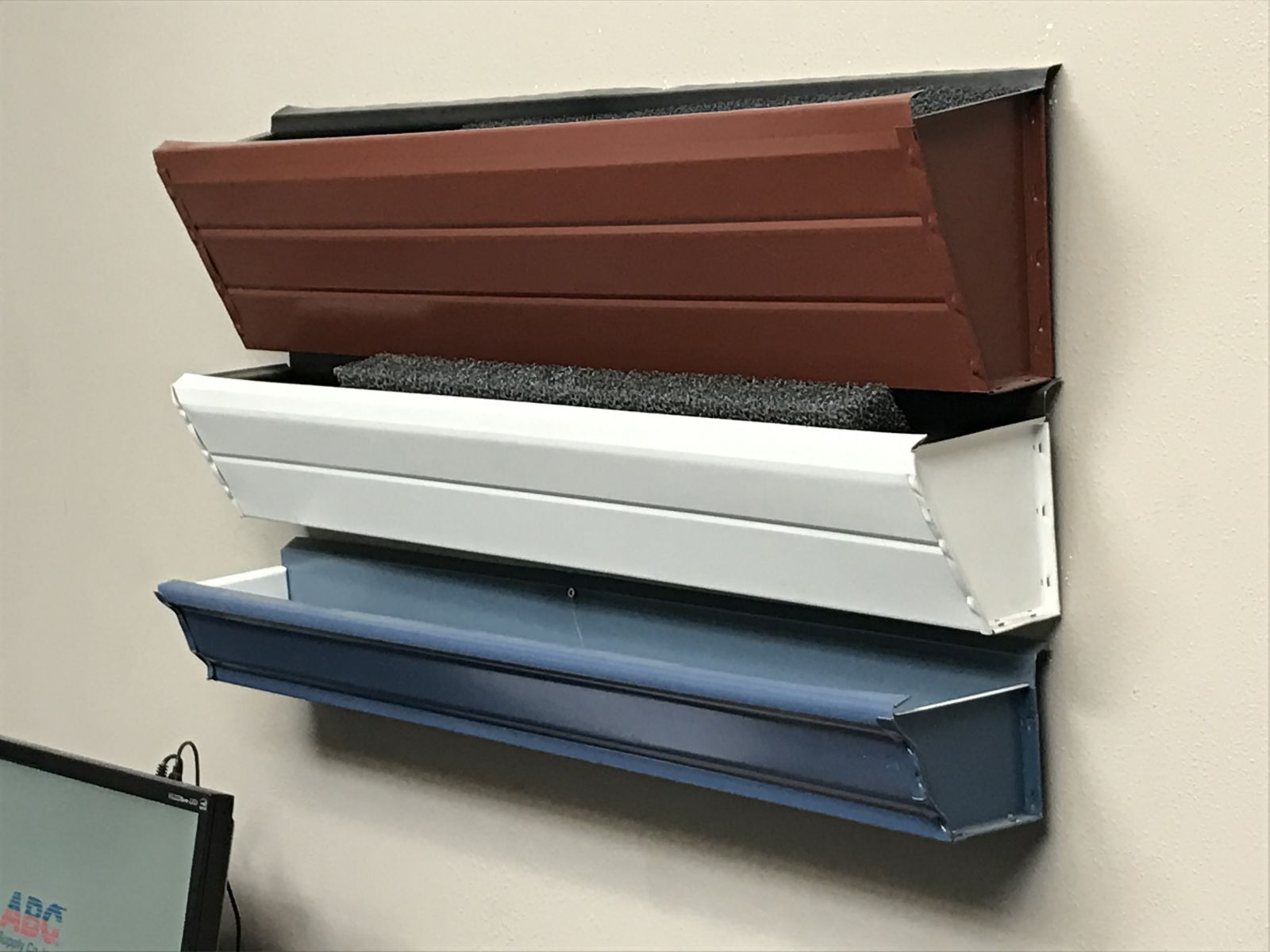 An image of three gutter types displayed on a wall