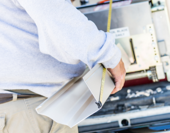 A professional technician replacing seamless gutters on a residential home in Belvedere, CA.