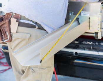 A professional technician measuring materials for gutter replacement in Napa County.